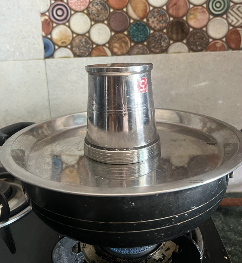 Covered black sauté pan with weight on top